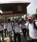 People carry a giant model of a house as they march along a street on the occasion of World Habitat Day in central Phnom Penh