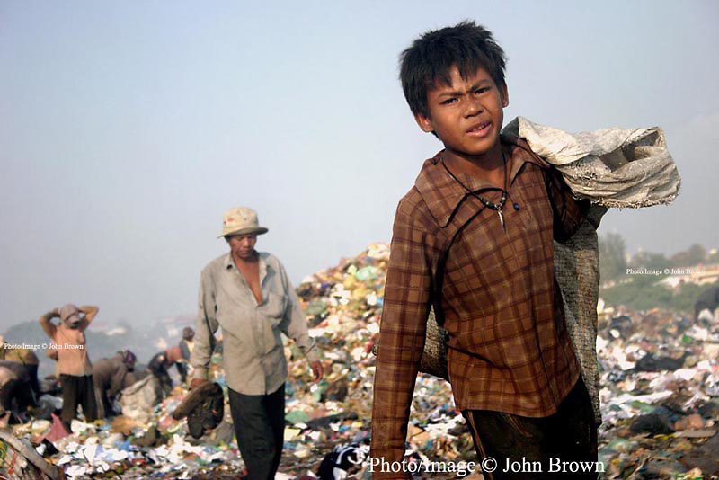 A young school-aged boy looks for recyclable material at The Stung Meanchey Landfill in Phnom Penh, Cambodia.