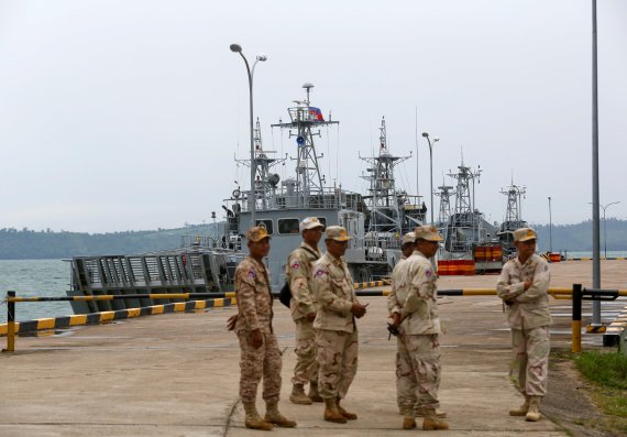 Sailors stand guard near petrol boats at the Cambodian Ream Naval Base in Sihanoukville