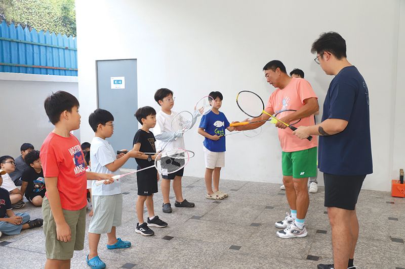 배드민턴 동호회원이 프놈펜한글학교 학생에게 라켓을 올바르게 쥐는 법을 지도하고 있다._WS